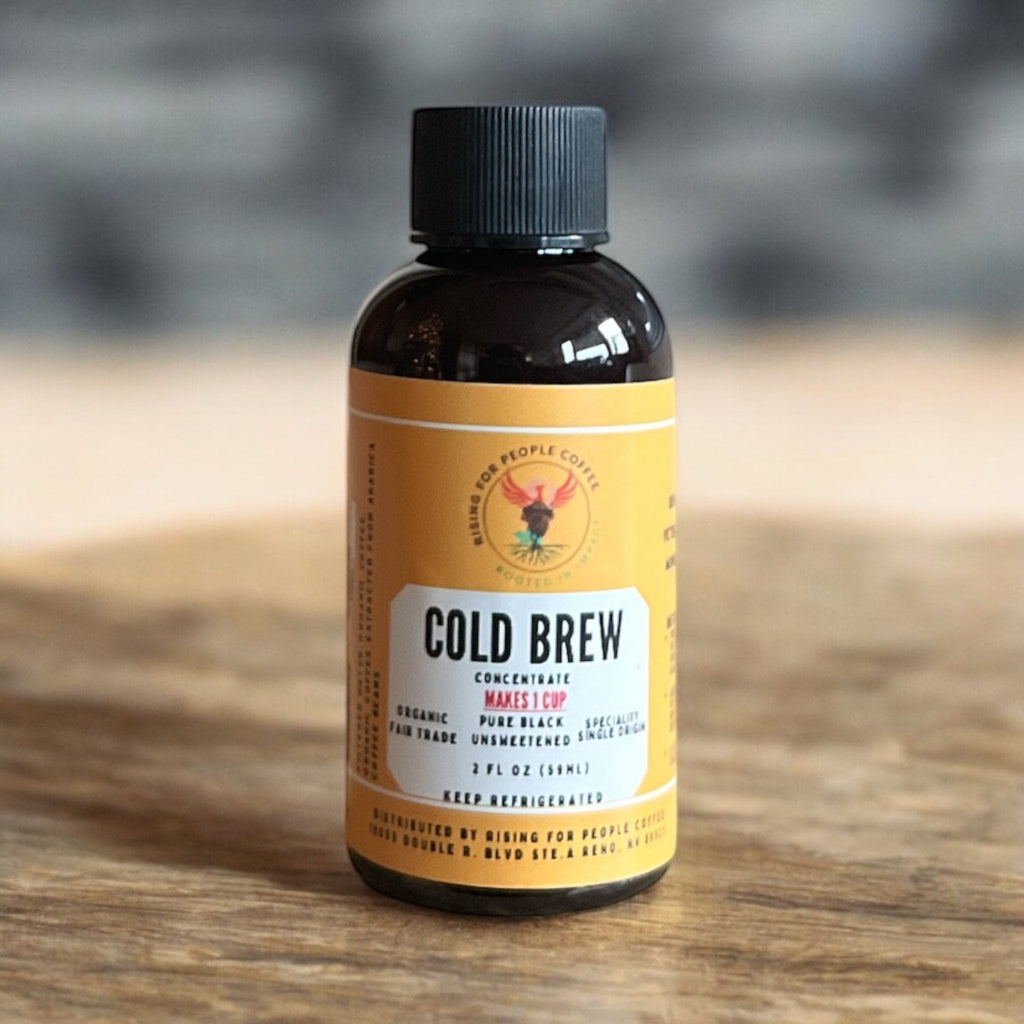 Organic Cold Brew Coffee Concentrate bottle surrounded by coffee beans and berries.