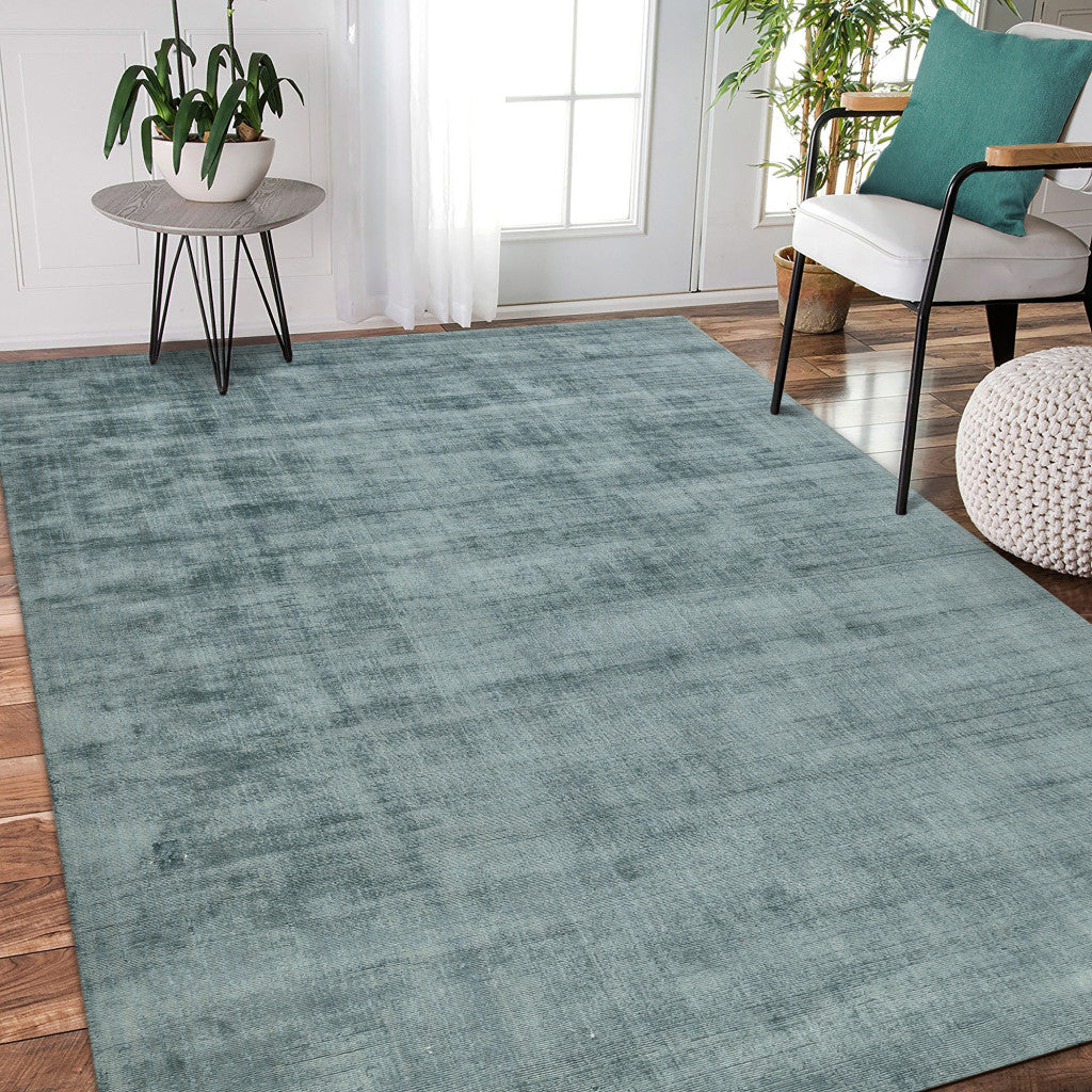 Side view of 5' x 8' Sea Green and Light Blue Abstract Hand Woven Area Rug by Homeroots