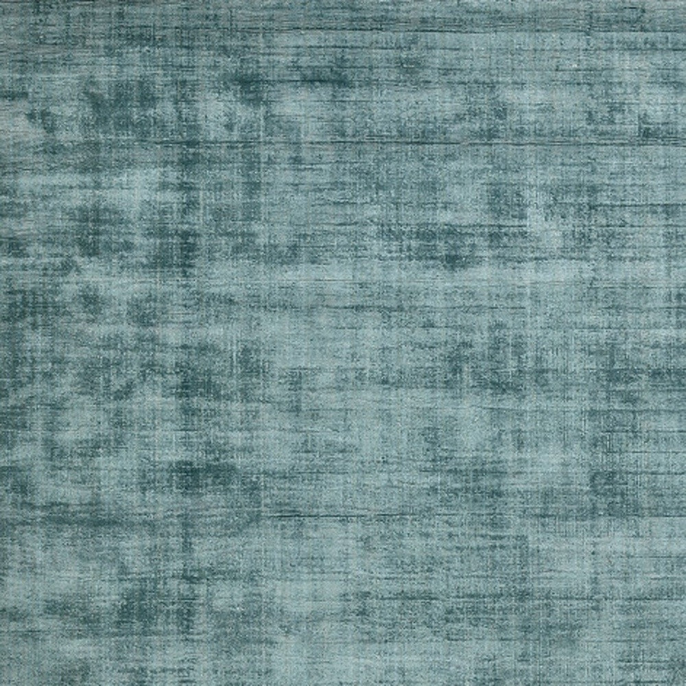 5' x 8' Sea Green and Light Blue Hand Woven Area Rug styled in a cozy bedroom by Homeroots