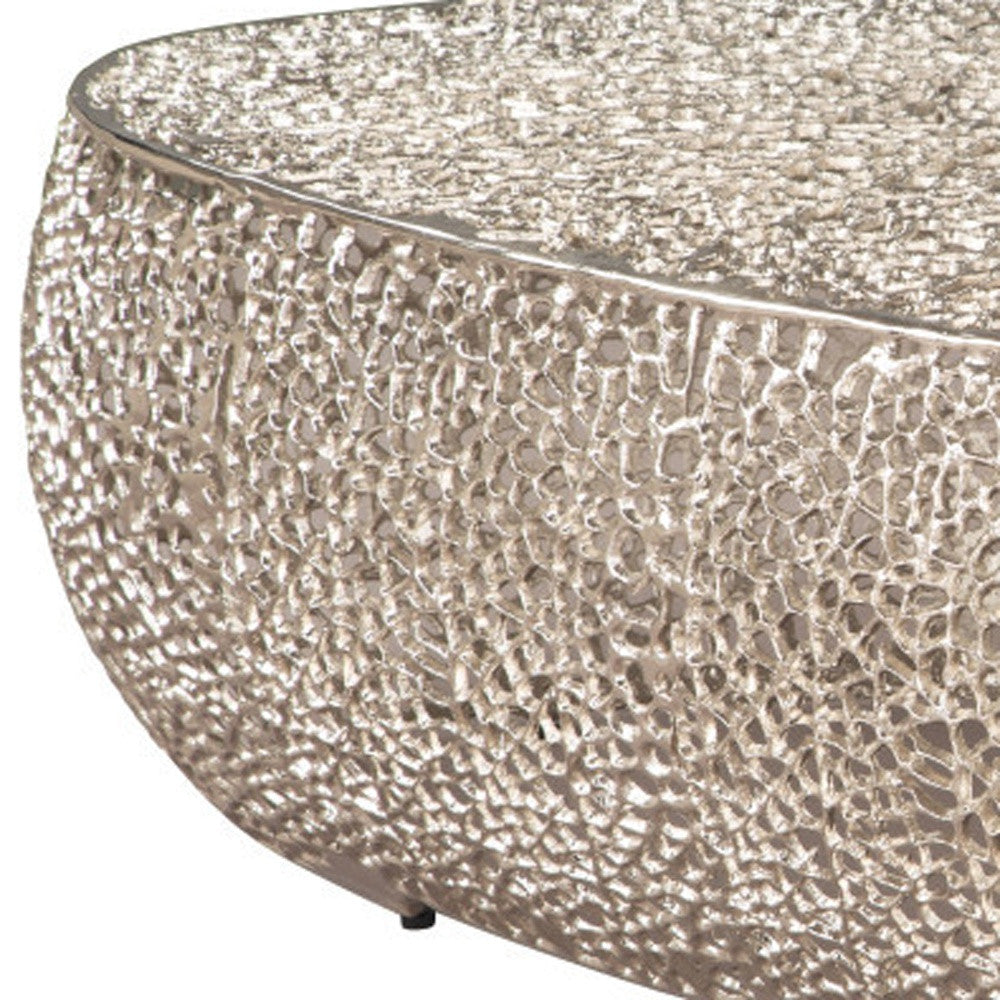 50" Silver Aluminum Oval Coffee Table with decorative items on top