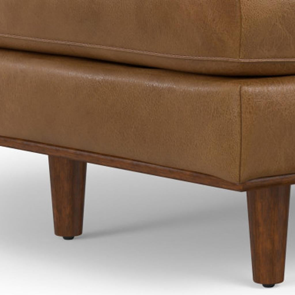Close-up of the rich brown leather upholstery of the ottoman