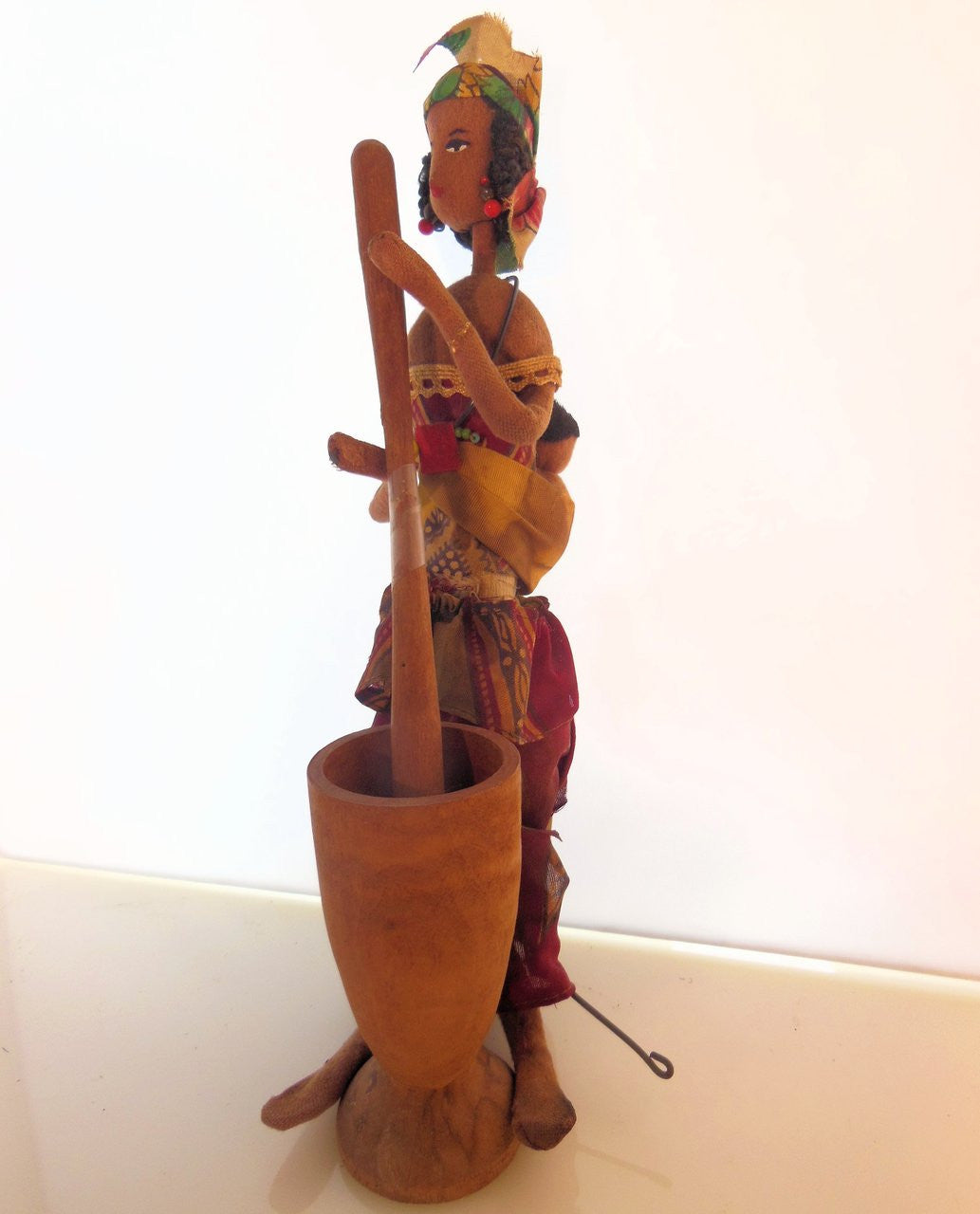 Doll displayed alongside other collectible art pieces