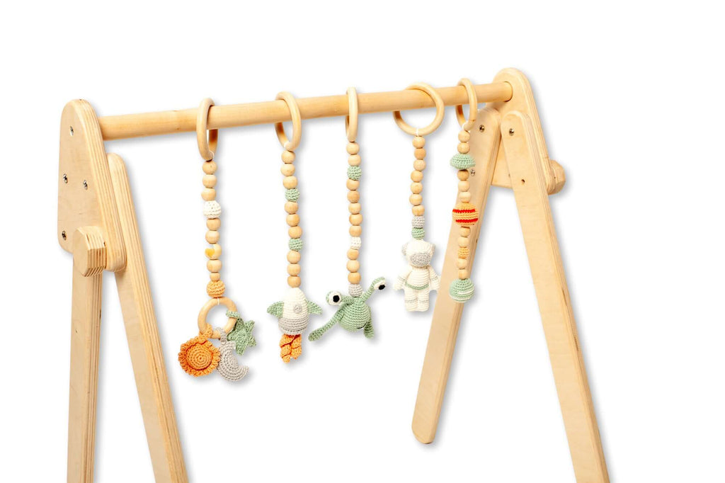 Close-up of handmade crochet hanging toys on the Montessori play gym