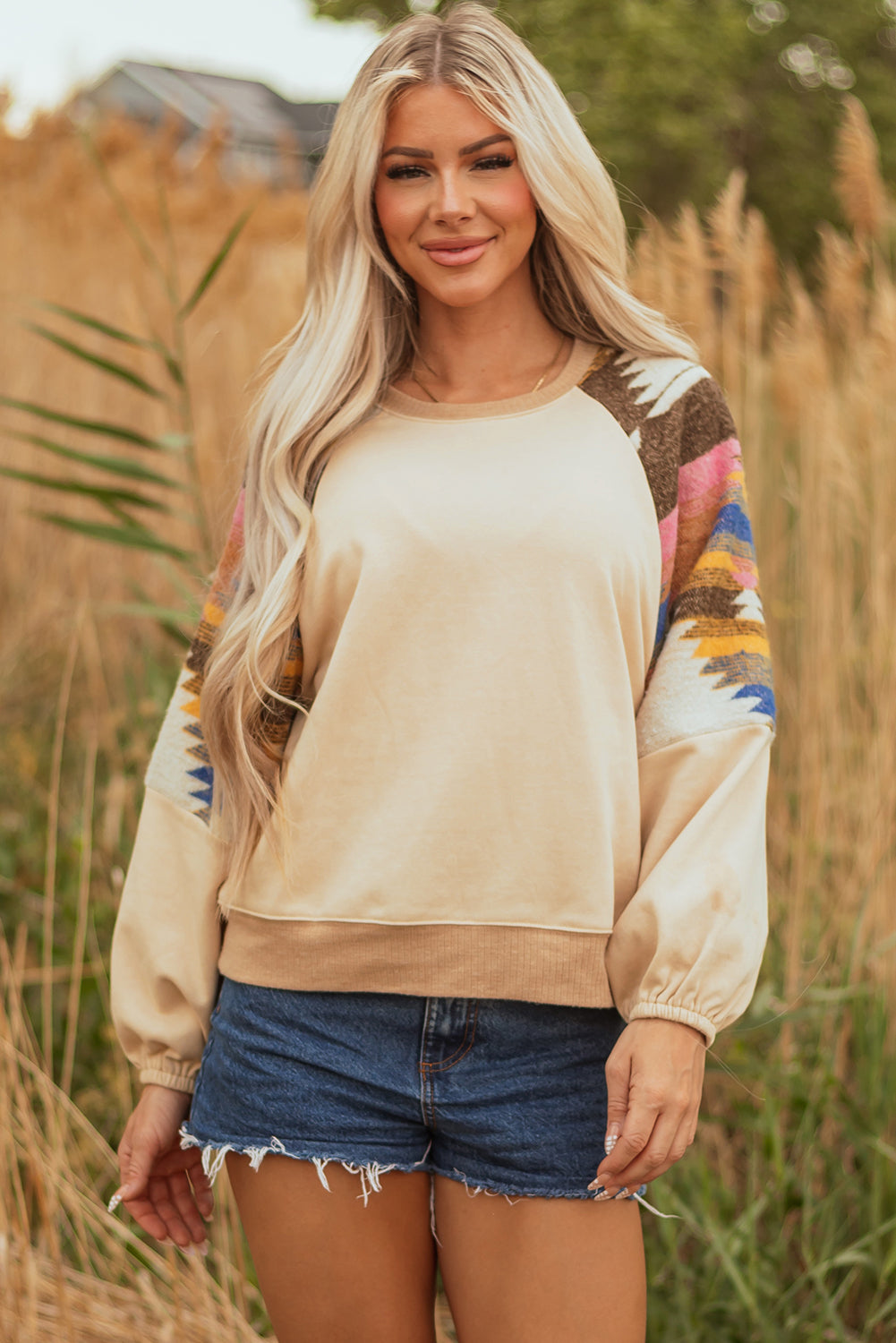 Model wearing Logan Aztec Patchwork Raglan Pullover Sweatshirt in casual setting by Threaded Pear