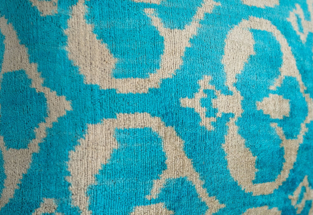 Decorative setup featuring the turquoise Ikat velvet throw pillow on a couch