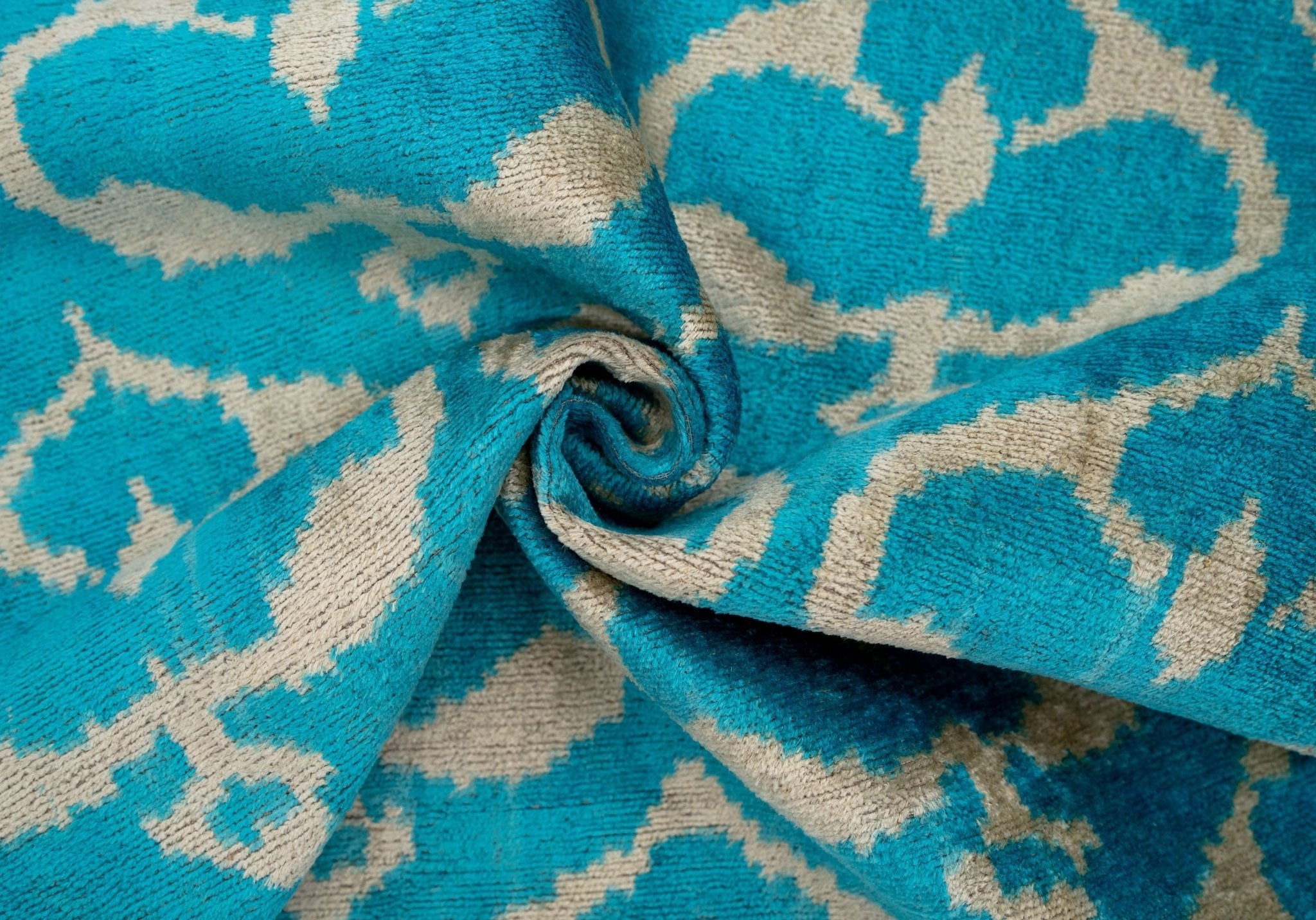 Side angle of the handmade turquoise Ikat velvet pillow showcasing its texture